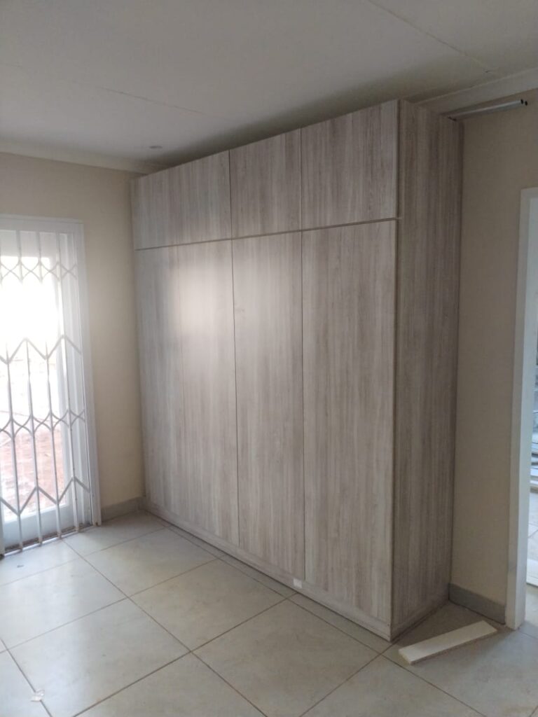 Full-height built-in bedroom cupboard in driftwood melamine finish