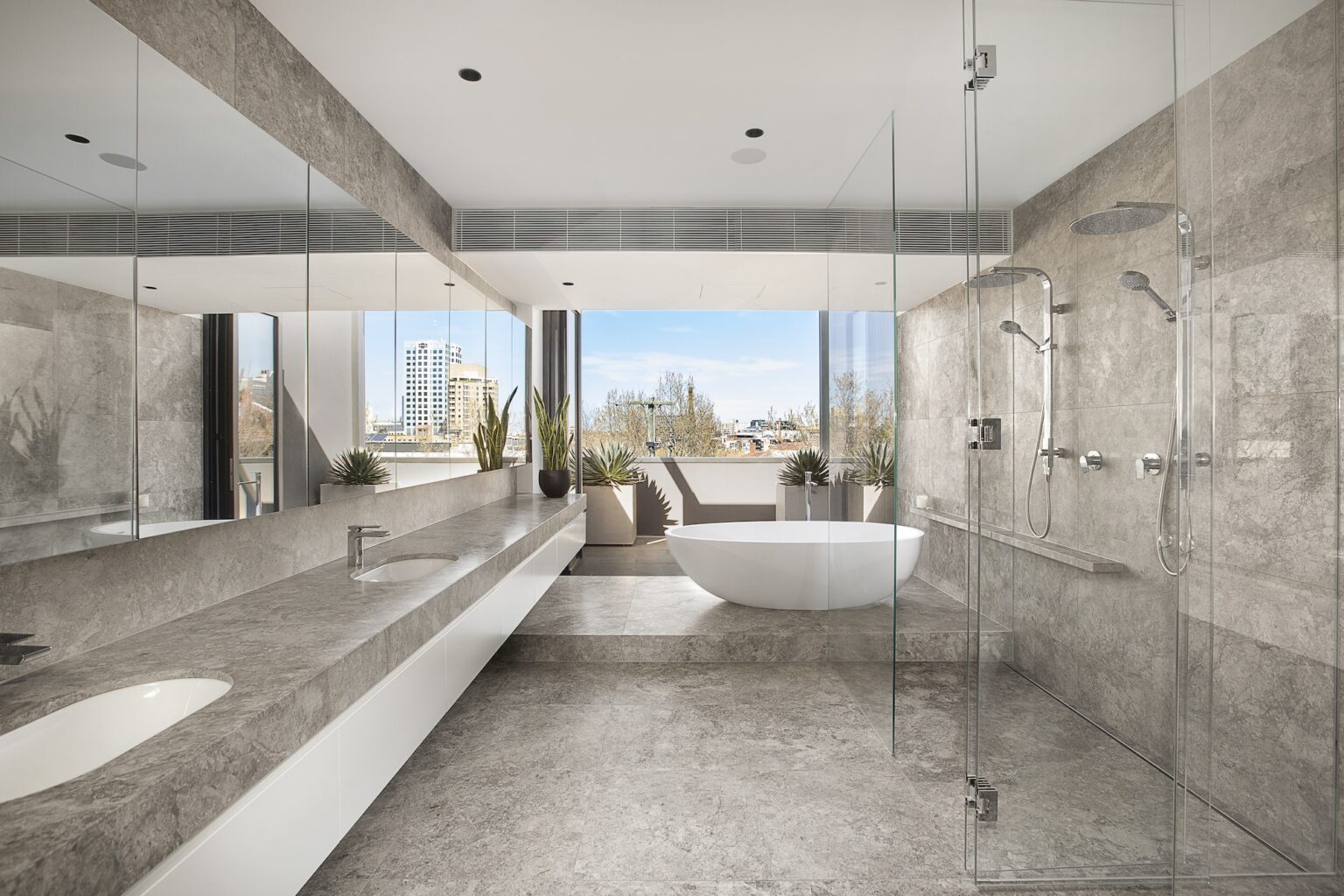 Stone bathroom with full-height frameless glass shower enclosure