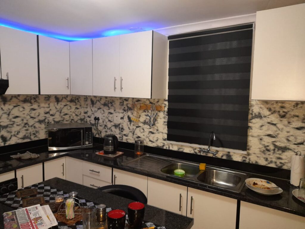 Gloss white kitchen with granite tops and LED cove lighting