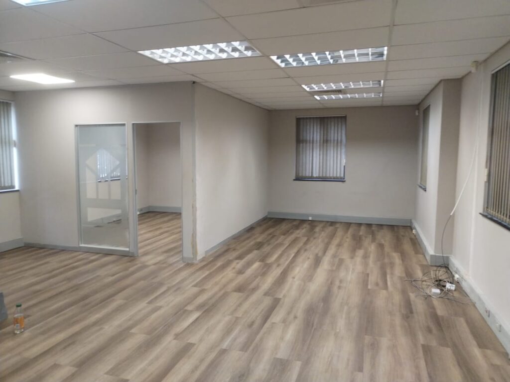 Open-plan office with frosted glass partition and vinyl timber flooring