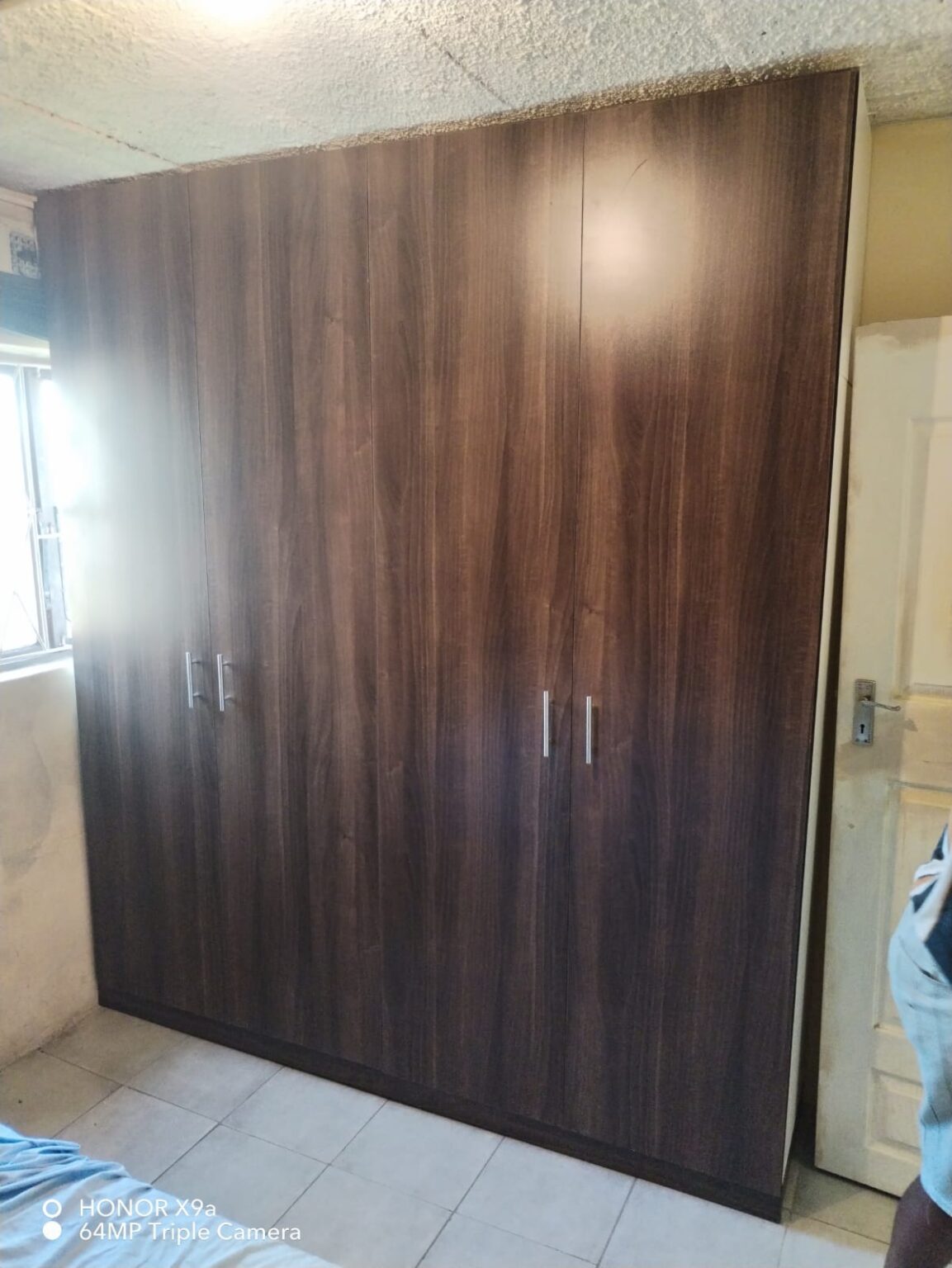 Four-door built-in wardrobe in dark walnut finish with steel handles